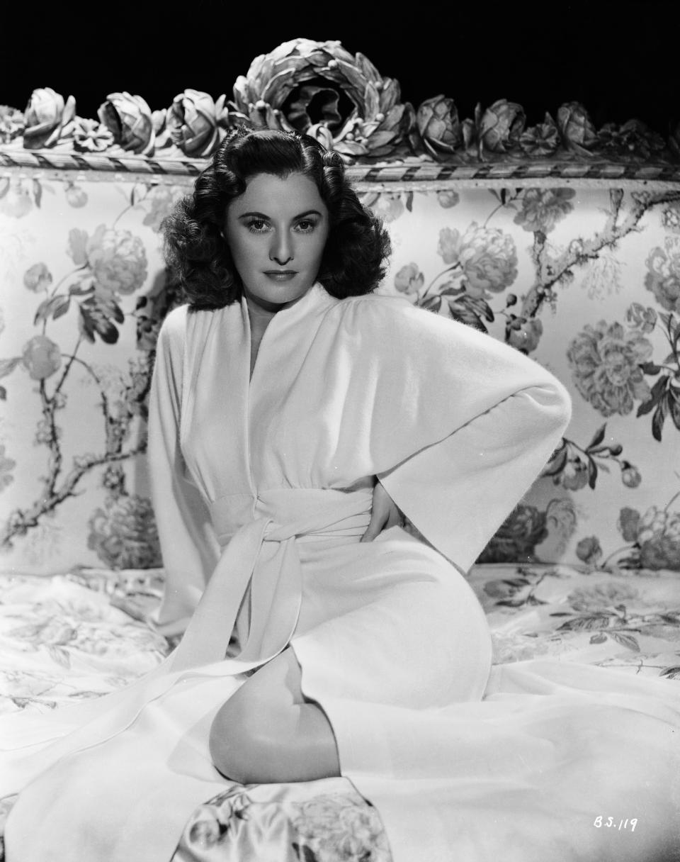 Stanwyck wears a white belted robe in a publicity still for "The Gay Sisters," 1942.