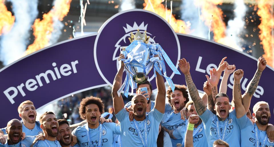 Manchester City's Belgian defender Vincent Kompany (C) holds up the Premier League trophy after their 4-1 victory in the English Premier League football match between Brighton and Hove Albion and Manchester City at the American Express Community Stadium in Brighton, southern England on May 12, 2019. - Manchester City held off a titanic challenge from Liverpool to become the first side in a decade to retain the Premier League on Sunday by coming from behind to beat Brighton 4-1 on Sunday. (Photo by Glyn KIRK / AFP) / RESTRICTED TO EDITORIAL USE. No use with unauthorized audio, video, data, fixture lists, club/league logos or 'live' services. Online in-match use limited to 120 images. An additional 40 images may be used in extra time. No video emulation. Social media in-match use limited to 120 images. An additional 40 images may be used in extra time. No use in betting publications, games or single club/league/player publications. /         (Photo credit should read GLYN KIRK/AFP/Getty Images)