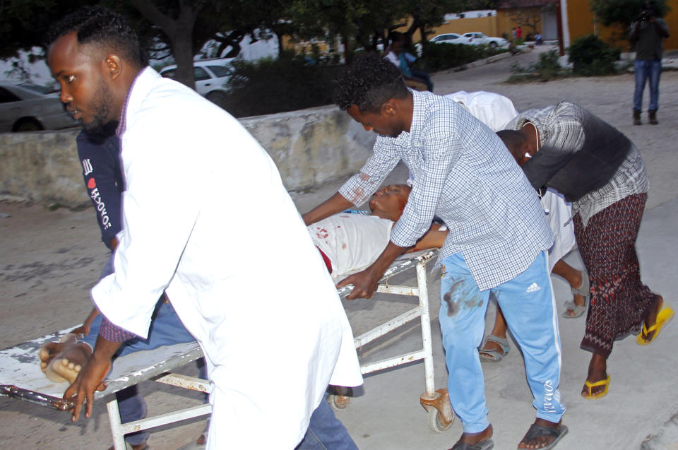 Medical workers help civilian on stretcher who was wounded in suicide bomb, at Madina hospital, Mogadishu, Wednesday, July 24, 2019. A suicide bomber walked into the office of Mogadishu's mayor and detonated explosives strapped to his waist, killing several people and badly wounding the mayor, Somali police said Wednesday. (AP Photo/Farah Abdi Warsameh)