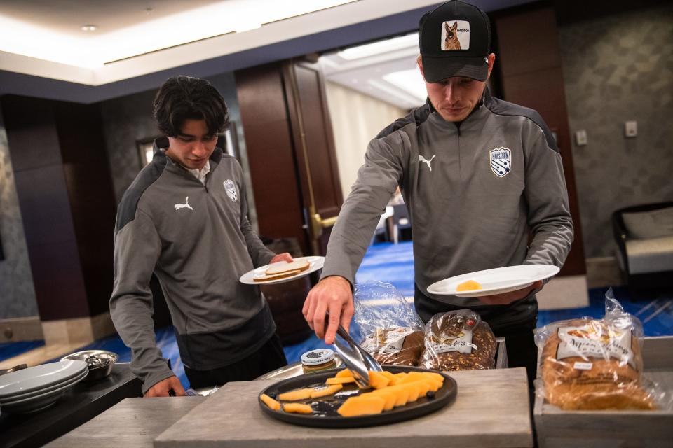 Hailstorm FC players Destan Norman, left, and Jackson Dietrich grab plates of food during a team lunch before a U.S. Open Cup third-round soccer match against the Colorado Rapids on Wednesday in Denver.