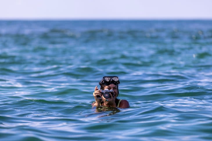 women taking photos in the ocean