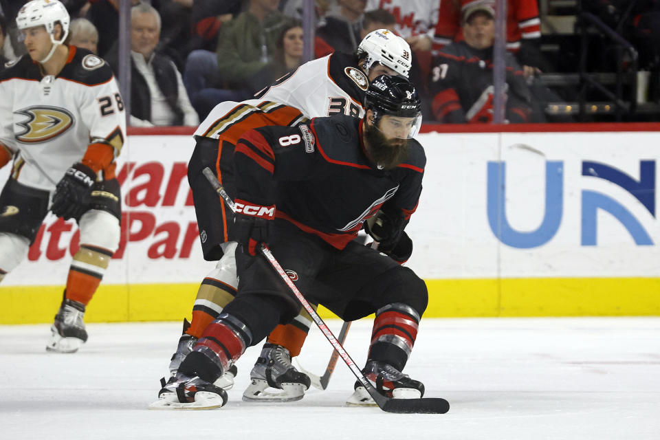 Carolina Hurricanes' Brent Burns (8) shields the puck from Anaheim Ducks' Derek Grant (38) during the first period of an NHL hockey game in Raleigh, N.C., Saturday, Feb. 25, 2023. (AP Photo/Karl B DeBlaker)