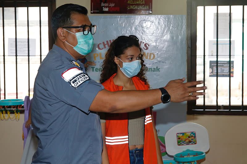 Heather Mack, an American woman jailed in 2015 with her boyfriend after being found guilty for playing a role in murdering her mother, is escorted by immigration officers after being released from Kerobokan Prison, in Badung