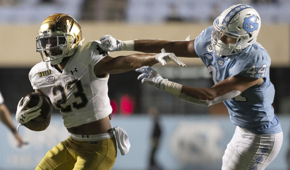 Notre Dame's Kyren Williams (23) rushes past North Carolina's Jeremiah Gemmell (44) during the fourth quarter of an NCAA college football game Friday, Nov. 27, 2020, in Chapel Hill, N.C. (Robert Willett/The News & Observer via AP, Pool)