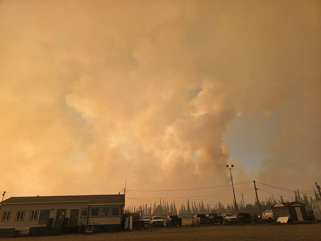 Smoke surrounded Fort Good Hope, N.W.T., around 11:30 p.m. on Saturday. N.W.T. Fire said a wildfire was at the edge of the community Sunday morning. (Sarah Krymalowski/CBC - image credit)