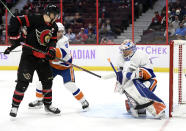 Ottawa Senators left wing Brady Tkachuk (7) and New York Islanders defenceman Andy Greene (4) watch as goaltender Ilya Sorokin (30) tries to control the puck during the second period of an NHL hockey game Tuesday, Dec. 7, 2021, in Ottawa, Ontario. (Justin Tang/The Canadian Press via AP)