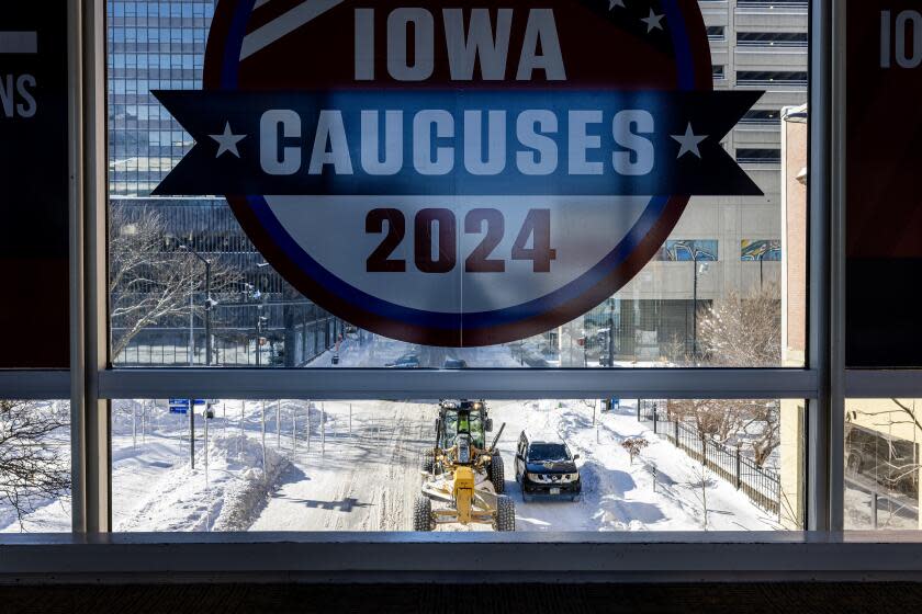 DES MOINES, IOWA - JANUARY 14, 2024: Icicles hang from a skywalk window as a snow plow clears streets downtown as severe freezing temperatures and snow have gripped Iowa during Iowa Caucus week on January 14, 2024 in Des Moines, Iowa.(Gina Ferazzi / Los Angeles Times)