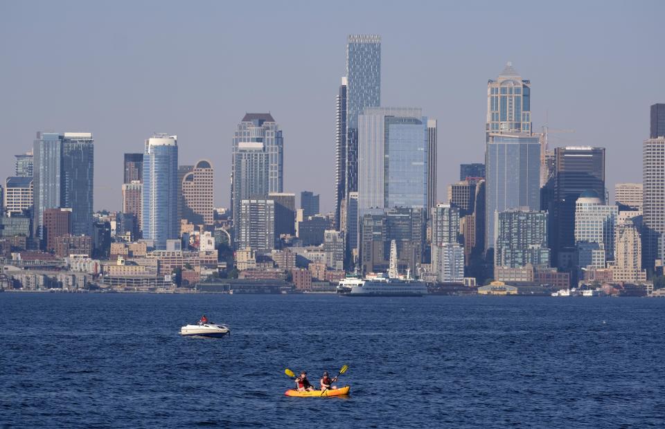 Kayakers and boaters ply the waters of Elliott Bay with the Seattle skyline behind during a heat wave hitting the Pacific Northwest, Sunday, June 27, 2021. The day before set a record high for the day with more record highs expected today and Monday. (AP Photo/John Froschauer)