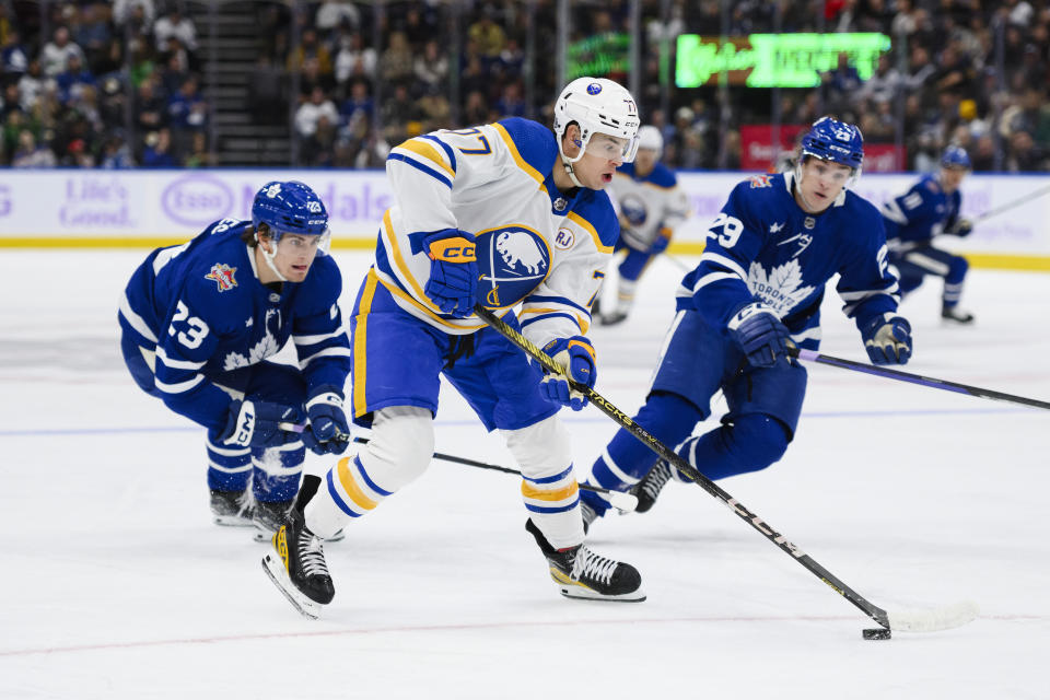 Buffalo Sabres' right wing JJ Peterka (77) attacks the net while defended by Toronto Maple Leafs left wing Matthew Knies (23) and right wing Pontus Holmberg (29) during the first period of an NHL hockey game Saturday, Nov. 4, 2023, in Toronto. (Christopher Katsarov/The Canadian Press via AP)