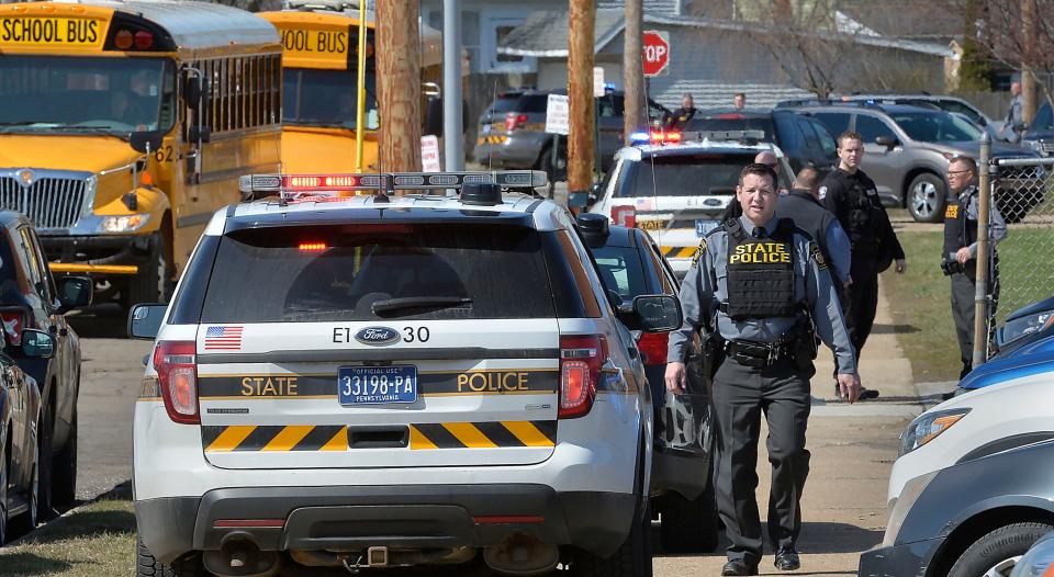 Pennsylvania State Police Trooper Andrew Hacke walks near Erie High School after a student was shot and injured in a hallway on Tuesday.