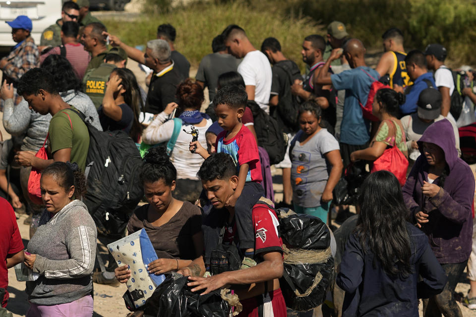 Migrants wait to be processed by the U.S. Customs and Border Patrol after they crossed the Rio Grande and entered the U.S. from Mexico, Thursday, Oct. 19, 2023, in Eagle Pass, Texas. Starting in March, Texas will give police even broader power to arrest migrants while also allowing local judges to order them out of the U.S. under a new law signed by Republican Gov. Greg Abbott. (AP Photo/Eric Gay)