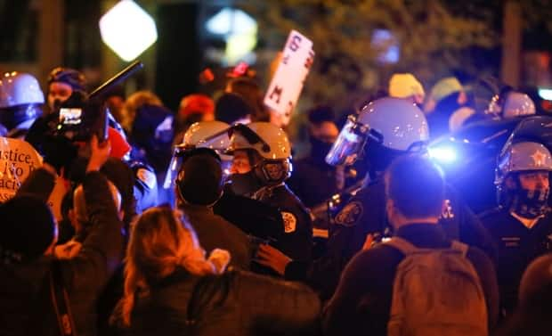 Chicago police hold back protesters last week who gathered over the police killing of 13-year-old Adam Toledo. The state has deployed National Guard troops, and businesses have been boarded up in anticipation of the verdict in the Chauvin murder trial.