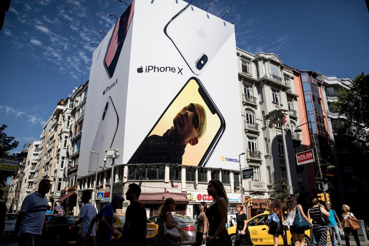 People cross the street underneath a billboard advertising the Apple iPhone X on August 15, 2018 in Istanbul, Turkey: Chris McGrath/Getty Images