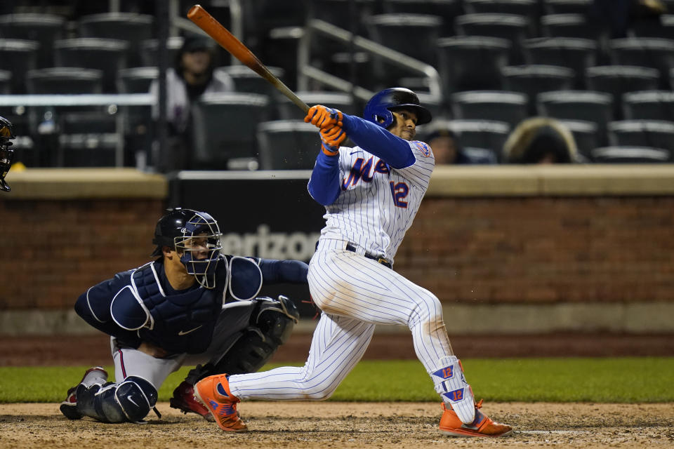 New York Mets' Francisco Lindor follows through on a two-run home run during the seventh inning of a baseball game, next to Atlanta Braves catcher William Contreras on Saturday, May 29, 2021, in New York. (AP Photo/Frank Franklin II)