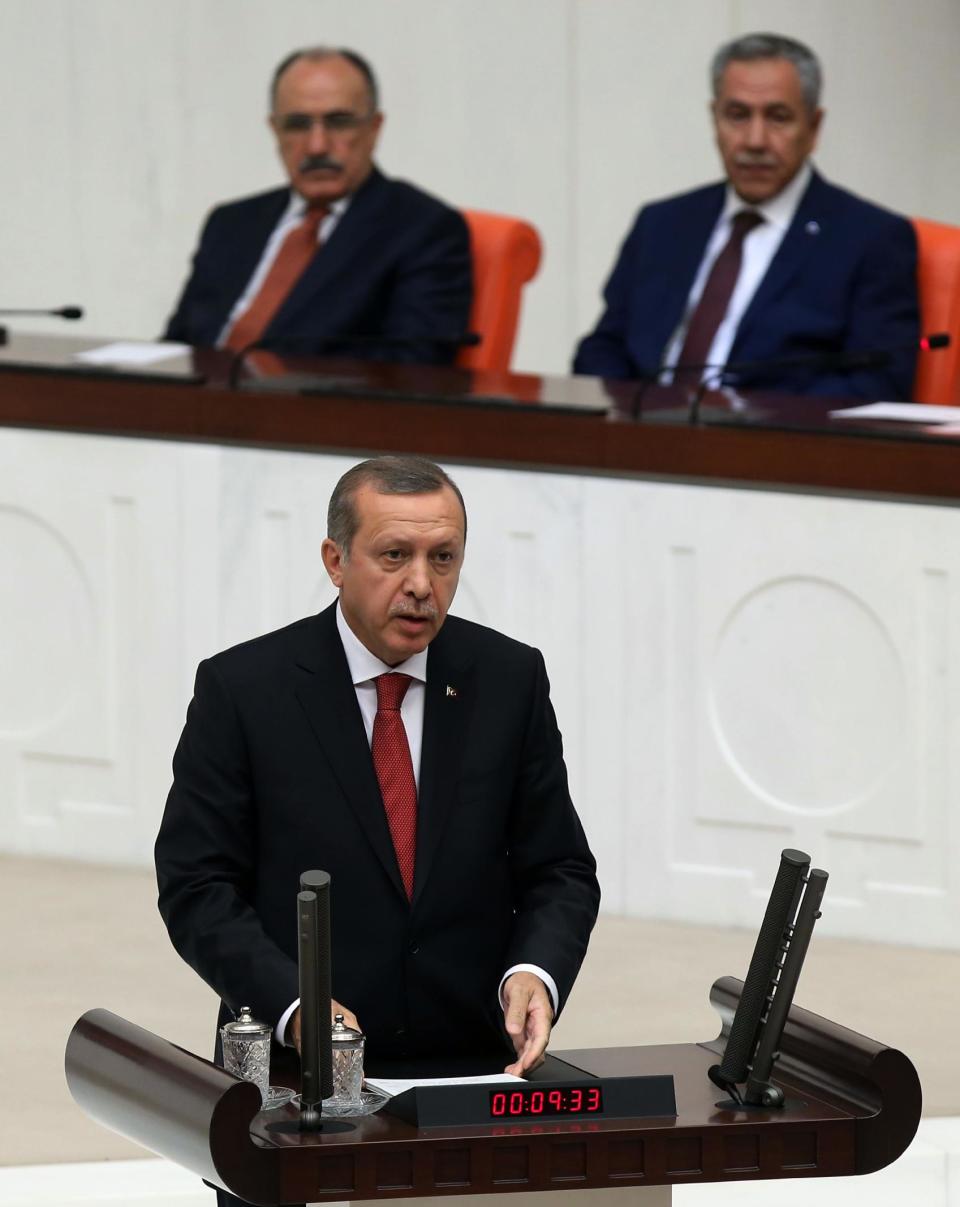 Turkish Prime Minister Recep Tayyip Erdogan addresses the parliament in Ankara, Turkey, Wednesday, April 23, 2014. Erdogan has issued a conciliatory message to Armenians on the eve of the anniversary of the massacre of Armenians almost a century ago, calling the events of World War I "our shared pain." In a statement released Wednesday in nine languages _ including Armenian _ Erdogan said he hoped Armenians who lost their lives are in peace and expressed condolences to their descendants.(AP Photo)