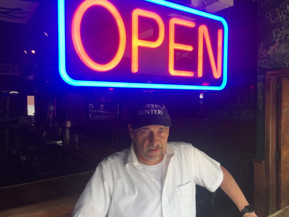 David Hunter, manager of Esox, stands beneath the new "open" sign at the Burlington bar July 20, 2021.