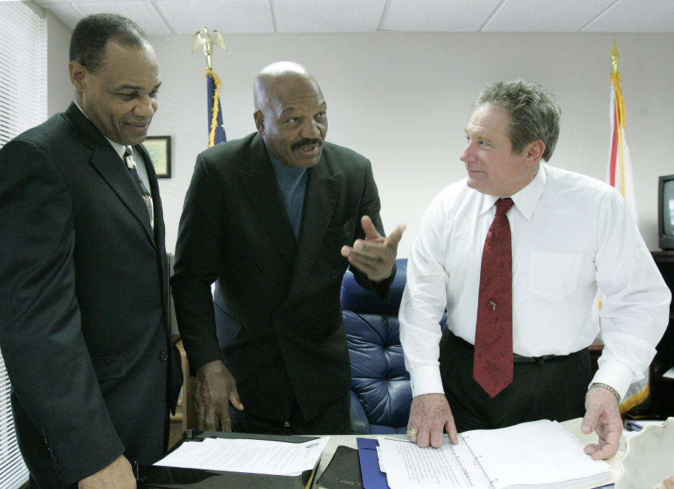 FILE - Jim Brown, Pro Football League Hall of Fame running back, actor, and activist, center, talks with Rep. Mitch Needelman, R-Melbourne, chairman of the House committee on juvenile justice, right, and Walt McNeil, Secretary of the Department of Juvenile Justice, left, prior to the meeting of the committee, Wednesday, Feb. 21, 2007, in Tallahassee, Fla. Brown addressed the committee regarding gang intervention and prevention. NFL legend, actor and social activist Jim Brown passed away peacefully in his Los Angeles home on Thursday night, May 18, 2023, with his wife, Monique, by his side, according to a spokeswoman for Brown's family. He was 87. (AP Photo/Phil Coale, File)