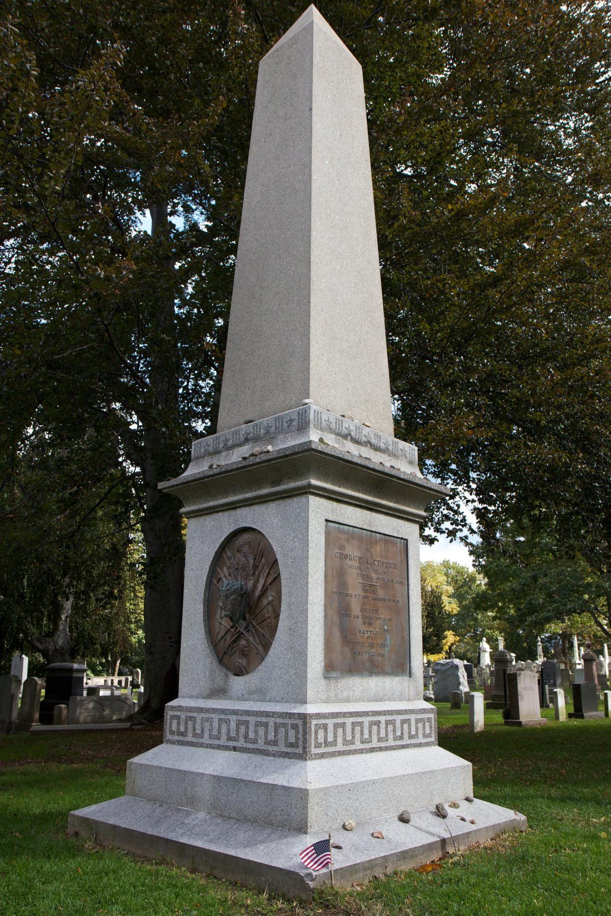 General George Custer's grave and monument, West Point Military Academy Cemetery, New York, surrounded by big trees with several other graves in the background