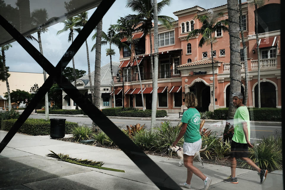 NAPLES, FL - SEPTEMBER 09: People walk through an empty downtown downtown Naples before the arrival of Hurricane Irma into Southwest Florida on September 9, 2017 in Naples, Florida. The Naples area could begin to feel hurricane-force winds from Irma by 11 a.m. Sunday and experience  wind gusts over 100 mph from Sunday through Monday. (Photo by Spencer Platt/Getty Images)