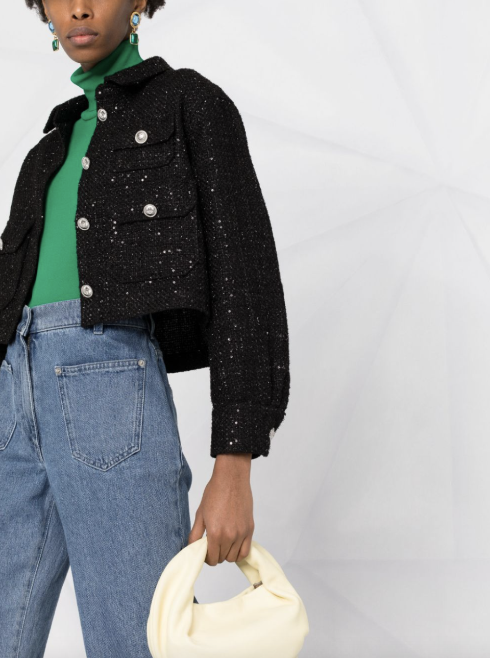 model in green shirt, blue jeans, and black Maje Sequinned Tweed Jacket (Photo via Farfetch)