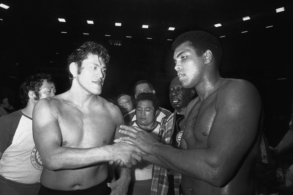 CORRECTS TO 1976, NOT 1979 - FILE - Wrestler Antonio Inoki, left, and world heavyweight boxing champion Muhammad Ali shake hands after a 15-round boxing- wrestling fight on June 26, 1976, at Tokyo's Budokan hall. A popular Japanese professional wrestler and lawmaker Antonio Inoki, who faced a world boxing champion Muhammad Ali in a mixed martial arts match in 1976, has died at 79. The New Japan Pro-Wrestling Co. says Inoki, who was battling an illness, died earlier Saturday, Oct. 1, 2022. (AP Photo, File)