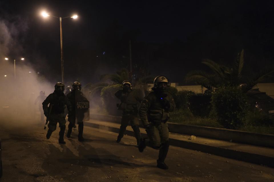 Riot policemen run against protesters during clashes in Athens, Tuesday, March 9, 2021. Severe clashes broke out Tuesday in Athens after youths protesting an incident of police violence attacked a police station with petrol bombs, and severely injured one officer. (AP Photo/Aggelos Barai)