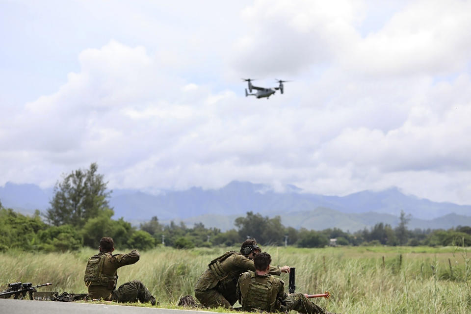 In this photo released by the Philippine DND Defense Communications Service and AFP Public Affairs Office, Australian forces fire at targets while a US Marines MV-22B Osprey is seen flying in the background as part of a large-scale combined amphibious assault exercise on Friday, August 25, 2023 at a naval base in San Antonio, Zambales. Australian and Filipino forces, backed by U.S. Marines, practiced retaking an island seized by hostile forces in a large military drill Friday on the northwestern Philippine coast facing the disputed South China Sea.(Philippine DND Defense Communications Service and AFP Public Affairs Office via AP)