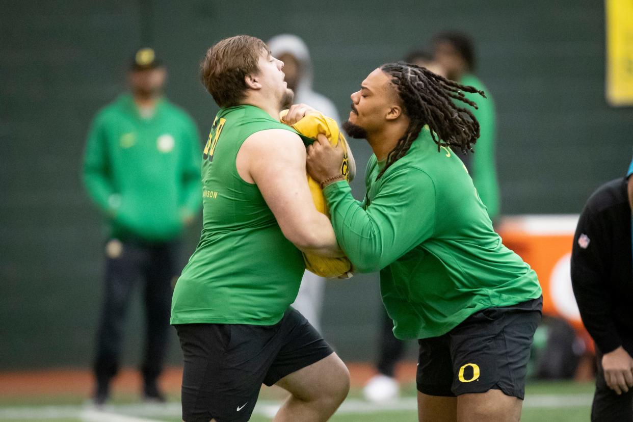 Oregon offensive linemen Steven Jones, right, and Jackson Powers-Johnson run drills during Oregon Pro Day Tuesday, March 12, 2024 at the Moshofsky Center in Eugene, Ore.