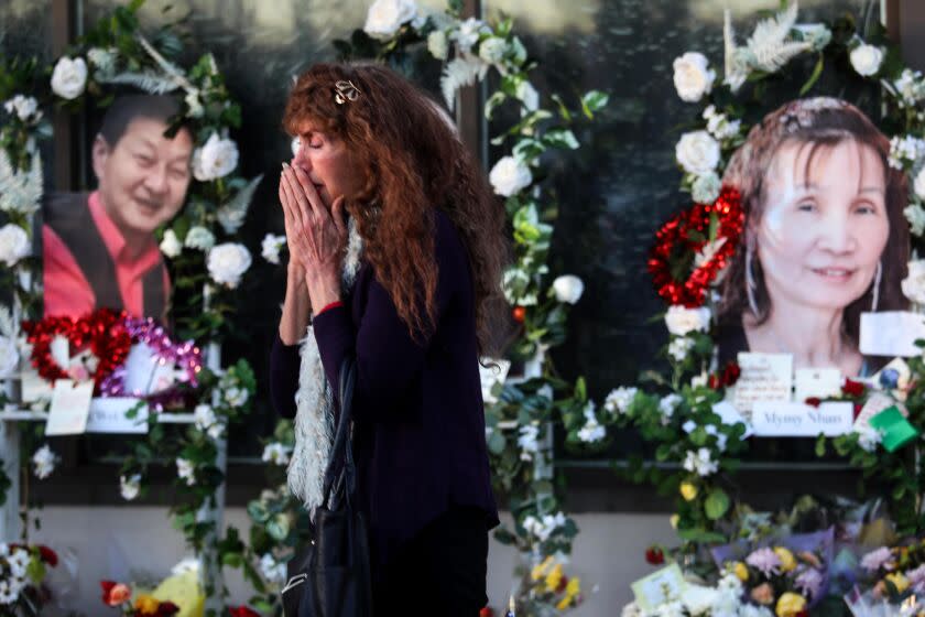 MONTEREY PARK, CA - JANUARY 26, 2023 - - Adelle Castro, 68, of Temple City, cries at the memorial for 11 people who died in a mass shooting during Lunar New Year celebrations outside the Star Ballroom Dance Studio in Monterey Park on January 26, 2023. "They were my family," said Castro who used to dance at the ballroom. "They introduced me to their culture and they were my family. I can't believe it. It's beyond understanding," Castro concluded. (Genaro Molina / Los Angeles Times)