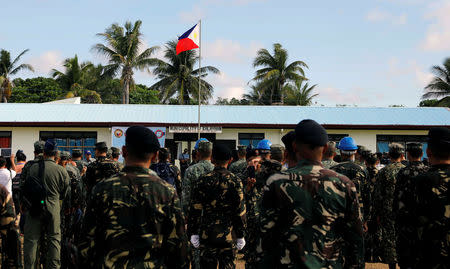 A Philippine flag flutters in Philippine occupied (Pagasa) Thitu island, in disputed South China Sea, as soldiers and civilians sing the country's national anthem April 21, 2017. REUTERS/Erik De Castro