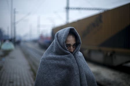 A Syrian refugee covers himself with a blanket at a makeshift camp for refugees and migrants at the Greek-Macedonian border, near the village of Idomeni, Greece March 15, 2016. REUTERS/Alkis Konstantinidis