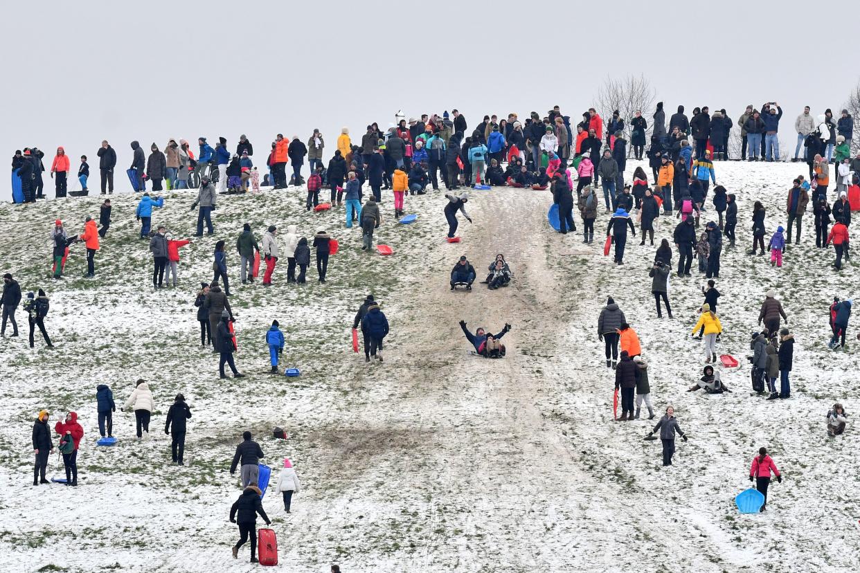 People play in the snow on Primrose Hill in London on January 24, 2021, as the capital experiences a rare covering of snow on Sunday. (Photo by JUSTIN TALLIS / AFP) (Photo by JUSTIN TALLIS/AFP via Getty Images)