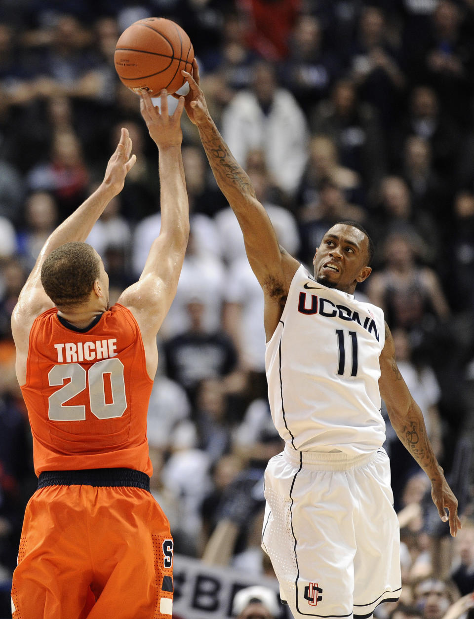 Connecticut's Ryan Boatright, right, blocks a shot-attempt by Syracuse's Brandon Triche in the final minutes of second half of an NCAA college basketball game in Hartford, Conn., Wednesday, Feb. 13, 2013. Connecticut won 66-58. (AP Photo/Jessica Hill)