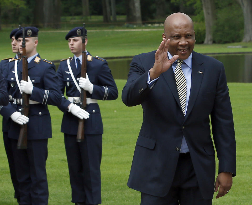 FILE - In this April 29, 2013, file photo, King Letsie III of Lesotho, right, waves in front of military honors at the Bellevue Palace in Berlin, Germany. The poor, mountainous kingdom encircled by South Africa has had a ceremonial, constitutional monarchy throughout decades of political instability since its independence from Britain in 1966. King Letsie III has openly criticized politicians for manipulating the military and shown interest in a more active political role. (AP Photo/Michael Sohn, File)
