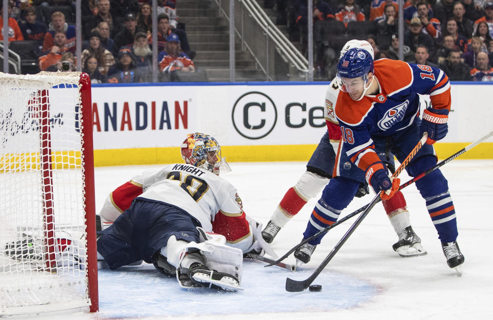 Florida Panthers goalie Spencer Knight, left, makes a save against Edmonton Oilers' Zach Hyman (18) during second-period NHL hockey game action in Edmonton, Alberta, Monday, Nov. 28, 2022. (Jason Franson/The Canadian Press via AP)