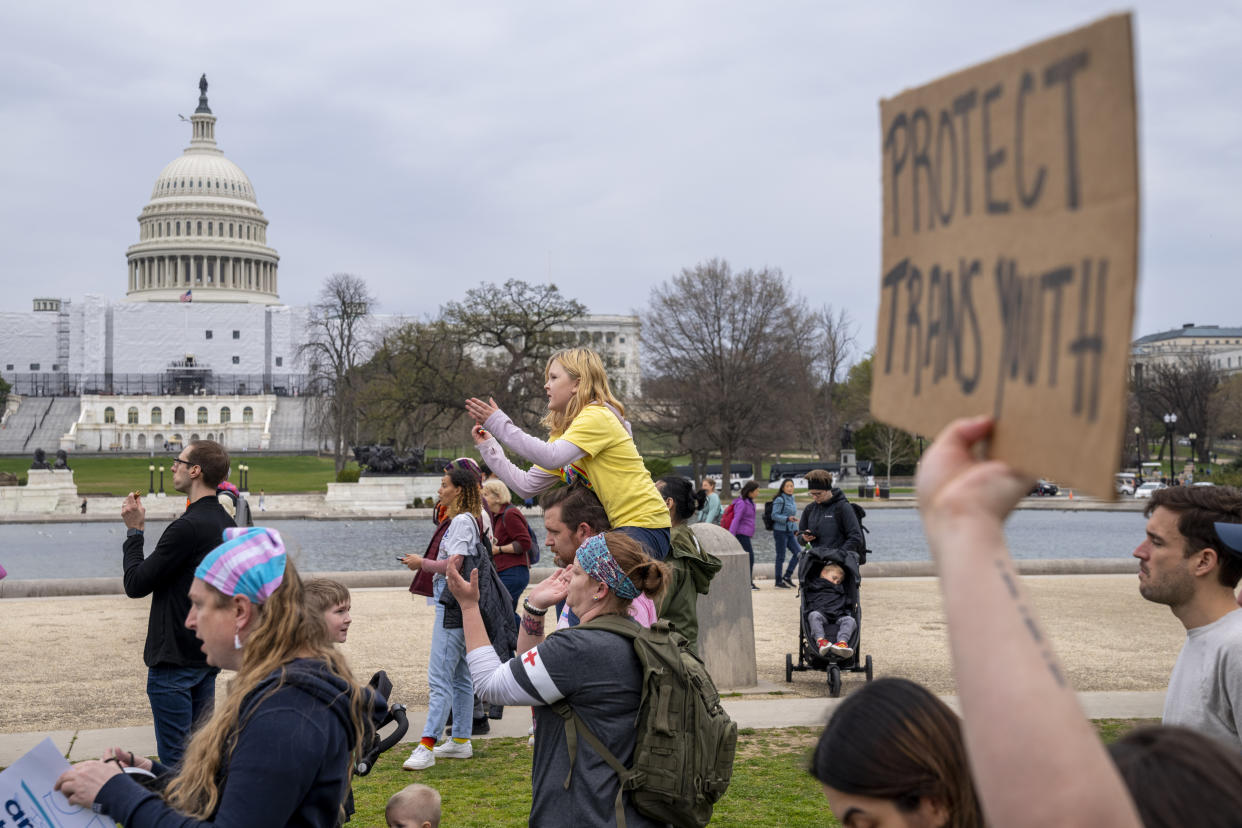 FILE - People attend a rally as part of a Transgender Day of Visibility, Friday, March 31, 2023, by the Capitol in Washington. Schools and colleges across the U.S. would be forbidden from enacting outright bans on transgender athletes under a proposal released Thursday, April 6, from the Biden administration, but teams could create some limits in certain cases, for example, to ensure fairness. (AP Photo/Jacquelyn Martin, File)