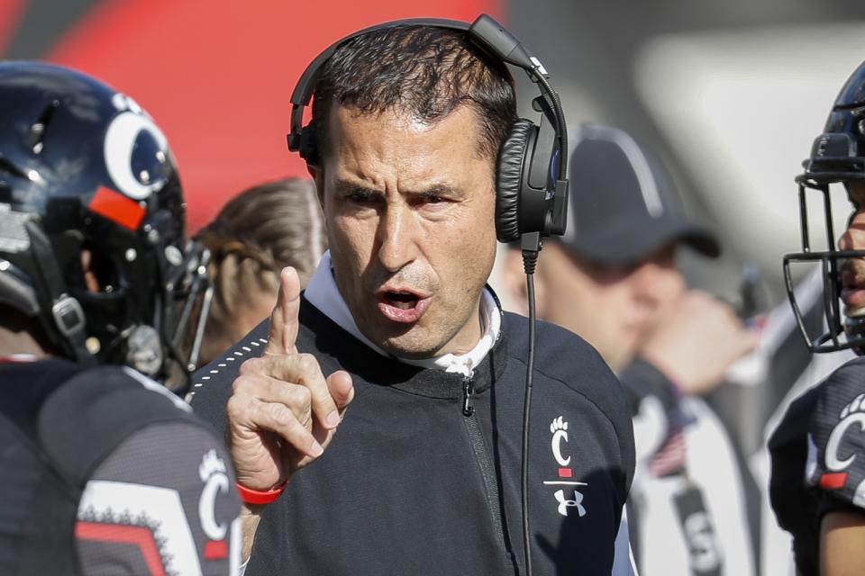 Cincinnati coach Luke Fickell speaks with linebacker Malik Clements (4) before a game against Navy in Cincinnati.