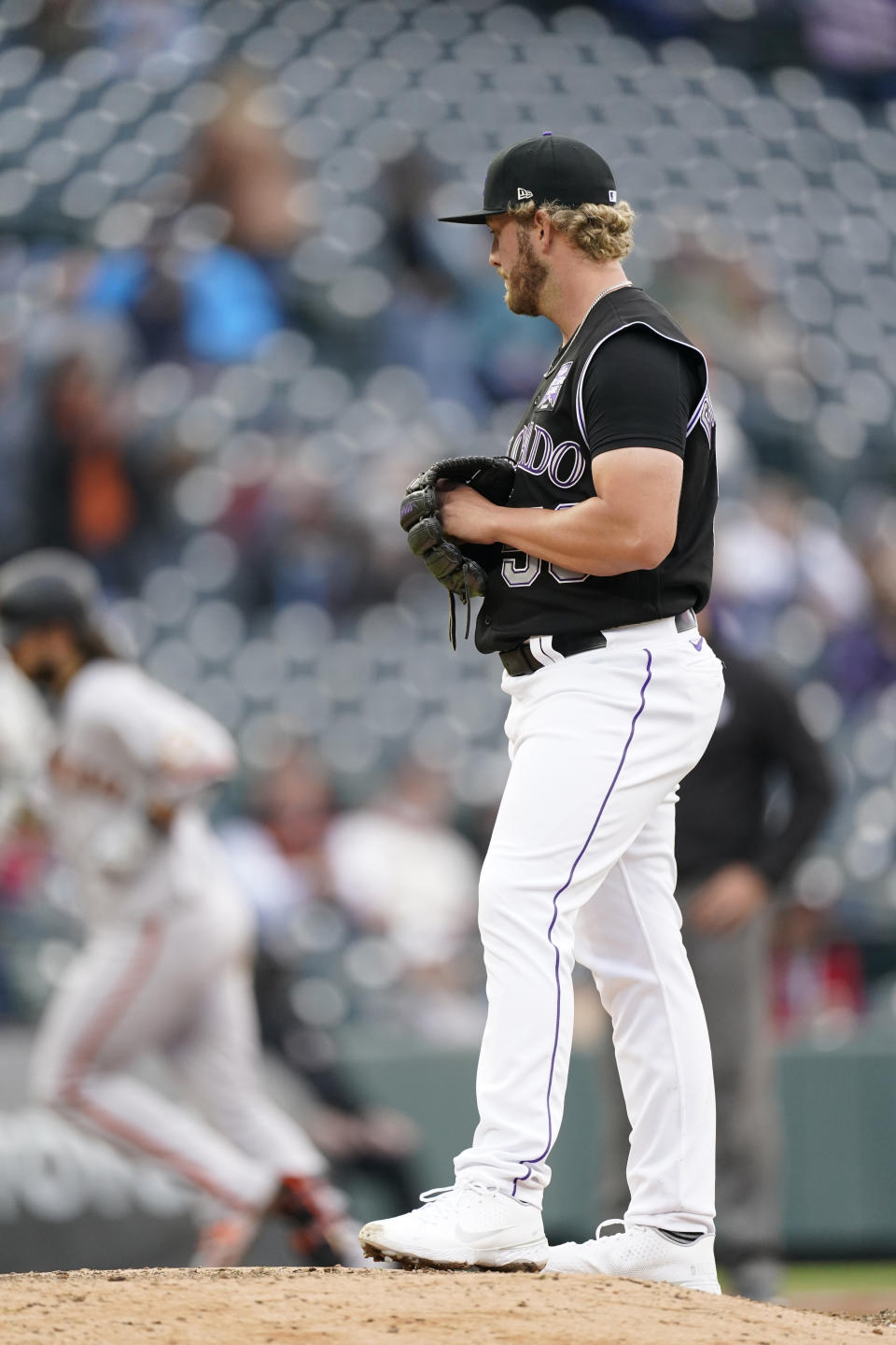 Colorado Rockies relief pitcher Lucas Gilbreath, front, looks on as San Francisco Giants' Brandon Crawford circles the bases after hitting a two-run home run in the sixth inning of game one of a baseball doubleheader Tuesday, May 4, 2021, in Denver. (AP Photo/David Zalubowski)