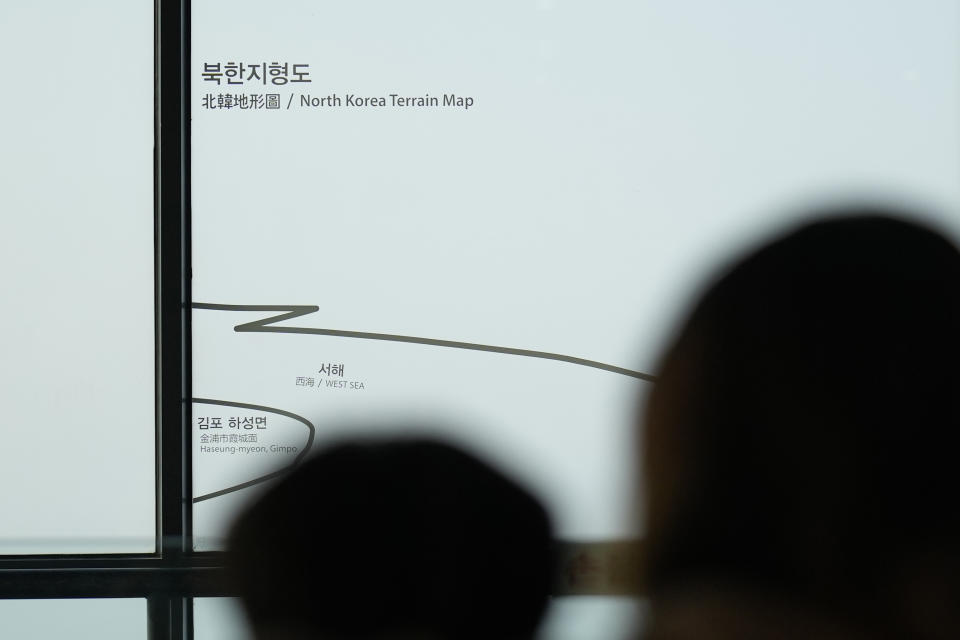 Visitors stand near a map of North Korea at the unification observatory in Paju, South Korea, Friday, Jan. 5, 2024. North Korea fired artillery rounds Friday near its disputed sea boundary with South Korea in violation of a fragile 2018 military agreement, officials said, prompting the South to plan similar drills. (AP Photo/Lee Jin-man)