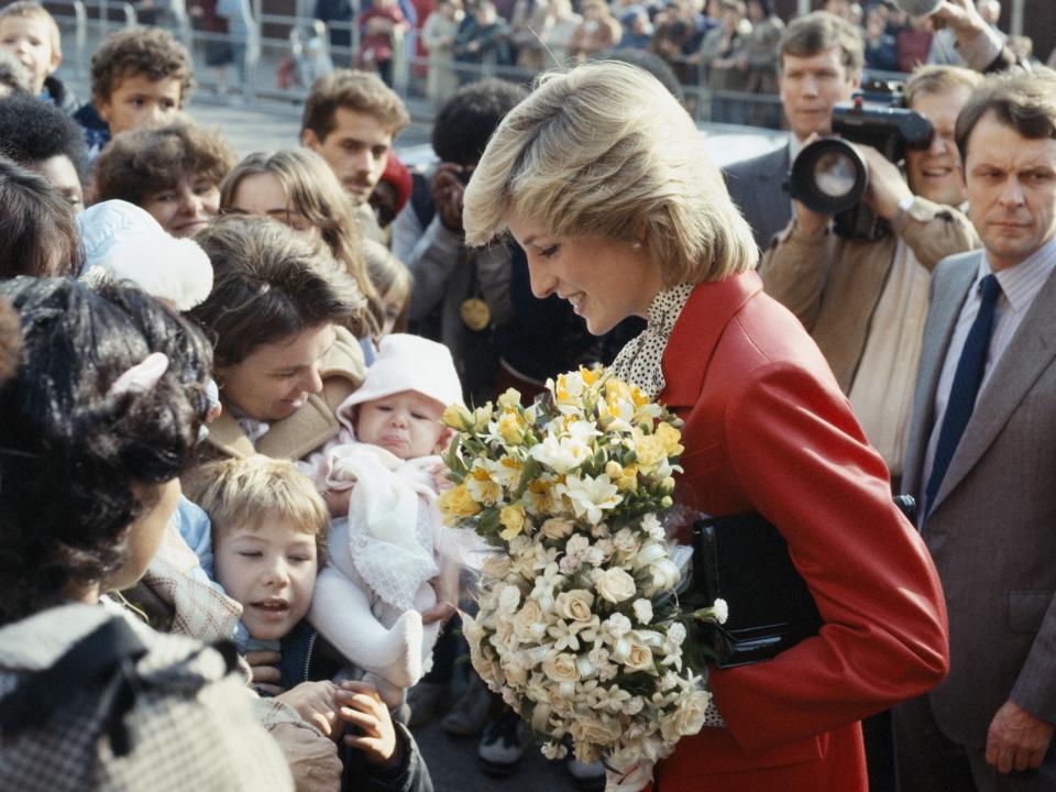 Princess Diana accepts flowers while visiting a community center in 1983.