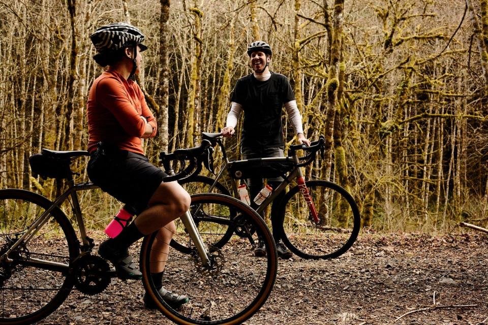 two cyclists taking a break on a gravel path discussing things