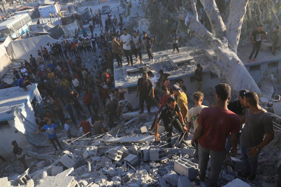 Palestinians search for bodies and survivors in the rubble of a residential building destroyed in an Israeli airstrike (Copyright 2024 The Associated Press All rights reserved)