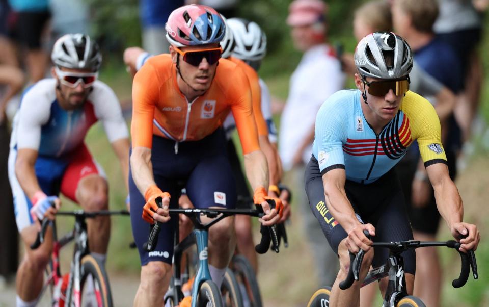 Belgium's Remco Evenepoel (R) cycles with the pack of riders (peloton) during the men's cycling road race during the Paris 2024 Olympic Games