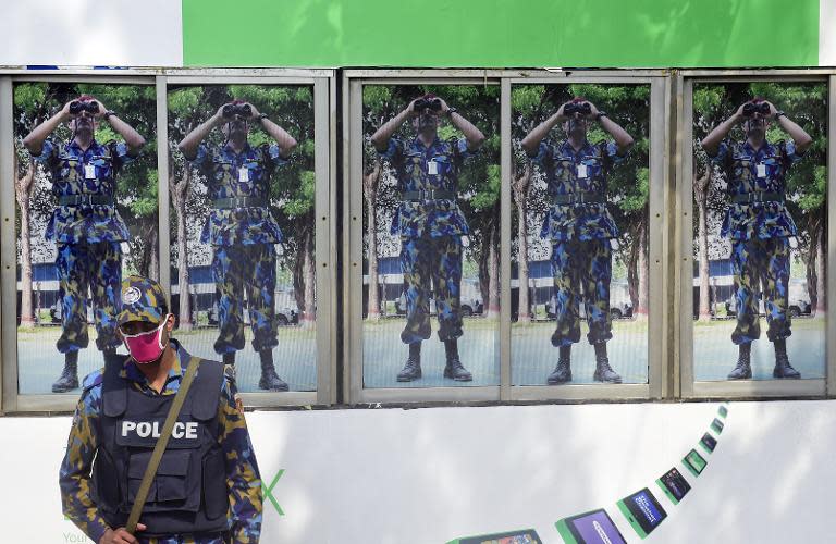 File photo shows local policeman standing guard in Dhaka on February 11, 2015