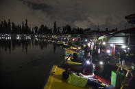 People cast the light of their cellphones from their trajinera boats as they watch the play La Llorona performed on top of a chinampa, a small artificial island at Cuemanco pier in Xochimilco, Mexico City, late Friday, Oct. 9, 2020, as the city promotes the upcoming Day of the Dead holiday at the end of the month, amid the COVID-19 pandemic. Legend has it that La Llorona drowned her children and then regretfully looks for them in rivers and towns, scaring locals who can hear her at night. (AP Photo/Marco Ugarte)
