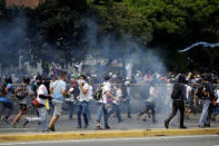 Opposition supporters run from tear gas as they clash with security forces during a rally against Venezuela's President Nicolas Maduro in Caracas, Venezuela, April 26, 2017. REUTERS/Marco Bello