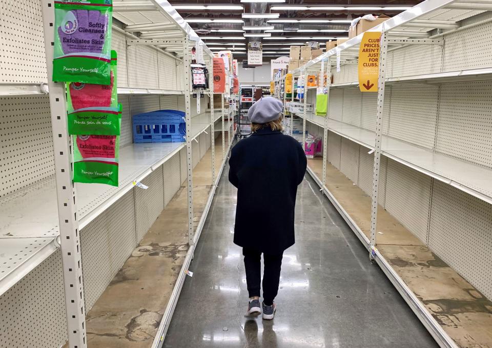 A shopper walks past empty shelves normally stocked with soaps, sanitizers, paper towels, and toilet paper at a Smart & Final grocery store, March 7, 2020 in Glendale, California. - Fears of coronavirus or COVID-19, the disease that has sickened more than 100,000 people worldwide and has killed more than 3,400, has led nervous residents to frantically stock up on canned food as well as cleaning and hygiene products. California prepared to disembark passengers from a virus-hit cruise ship as officials played down any risk to local communities. (Photo by Robyn Beck / AFP) (Photo by ROBYN BECK/AFP via Getty Images)