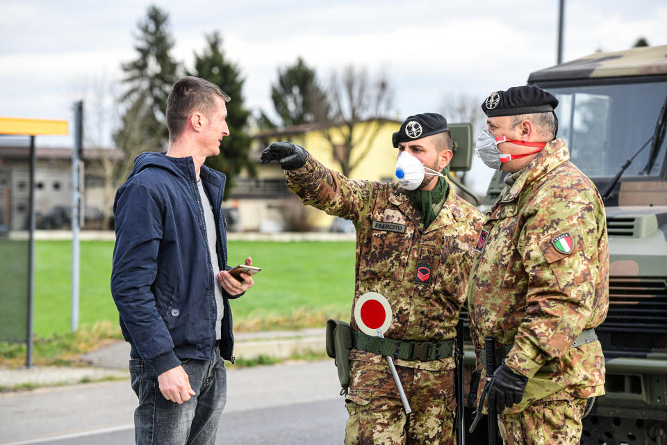 Castiglione d�Adda, Italy - 27 February 2020: Military personnel wearing protective respiratory masks gesticulate at the border of the isolated small town of Castiglione d�Adda as measures are taken to contain the outbreak of Coronavirus COVID-19 (Photo by Piero Cruciatti/Sipa USA)