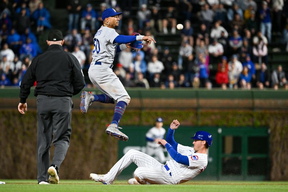 Mookie Betts turns a double play Thursday while former teammate Cody Bellinger slides in.