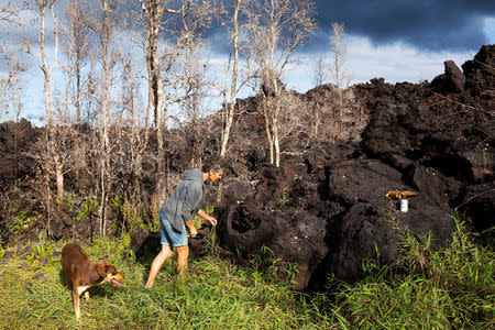 Carrie Fischer, 61, of Kapoho, who was forced to leave her home after the Kilauea Volcano erupted last summer, looks at hardened lava after returning to Kapoho, in Hawaii, U.S., March 29, 2019. Picture taken March 29, 2019. REUTERS/Terray Sylvester